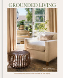Book cover of 'Grounded Living' by Anita Yokota featuring a living room with a couch, ottoman, and plants.