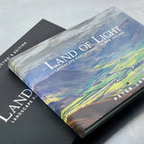 A hardback collector's edition book titled 'LAND OF LIGHT' by Peter Latham, featuring a scenic photograph of New Zealand's landscape on the cover.