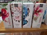 A selection of Banks & Co Botanicals lotions in various fragrances, displayed on a shelf. The packaging features floral designs with names of the fragrances like French Rose, Manuka, and Hibiscus prominently displayed.