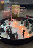 Decorative sand scene with candles, trees, and houses on a table, featuring Sand Wax products.