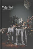 Book cover of 'Winter Wild' with a candlelit table setting and chandelier.