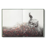 An open art book or sketchbook showing a detailed black and white pencil drawing of a rabbit standing on a stone pedestal, with a swirling field of red, orange, and gray fish-like forms below, photographed against a plain white background.