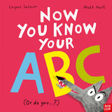 Book cover of 'Now You Know Your ABC' with colorful letters and a cartoon character on a pink background.