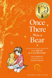 Front cover of the children's book 'Once There Was a Bear' featuring a bright orange background, gold tree illustration, and an illustration of a child sitting with a teddy bear. A gold 'Celebrating 100 Years Winnie-the-Pooh' seal appears at the top right.